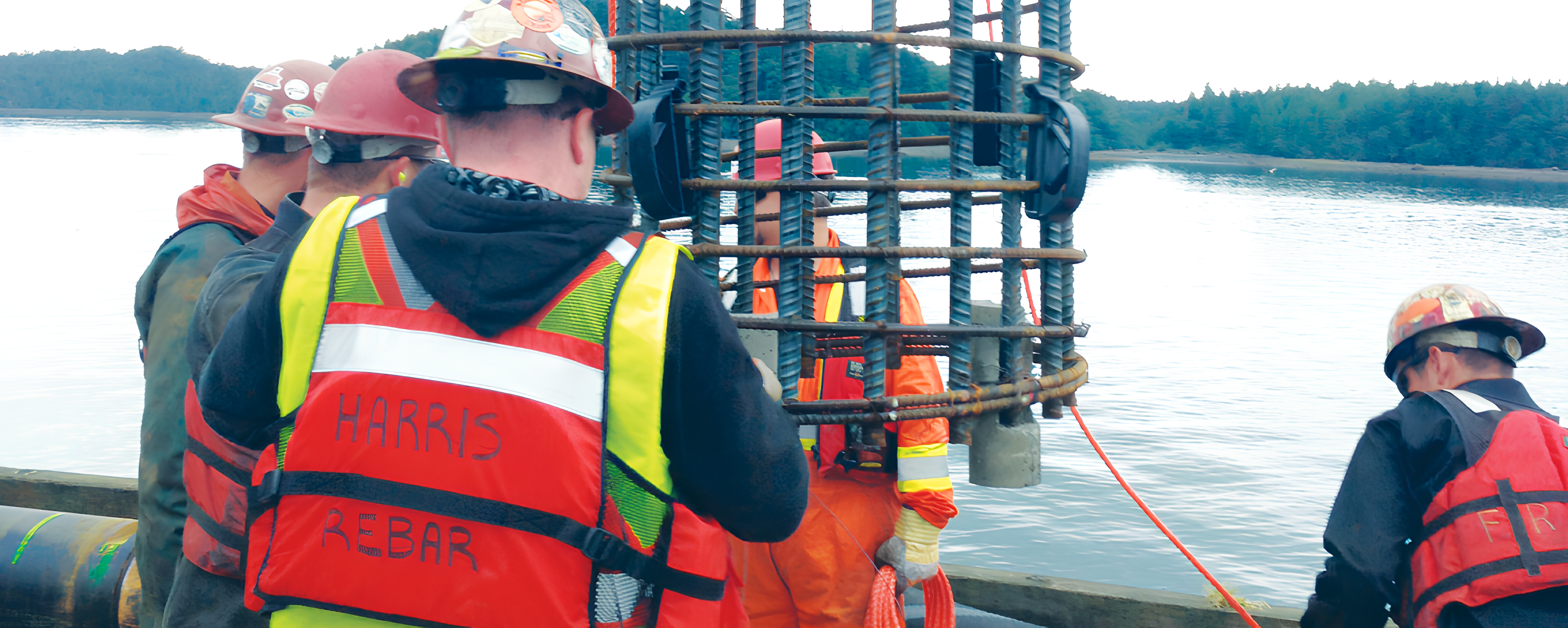 Crews placing a centralized rebar cage on a marine project